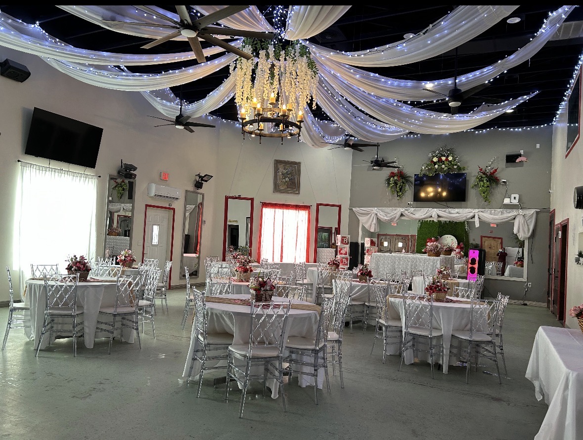 Main party hall with warm lighting and balloon arches